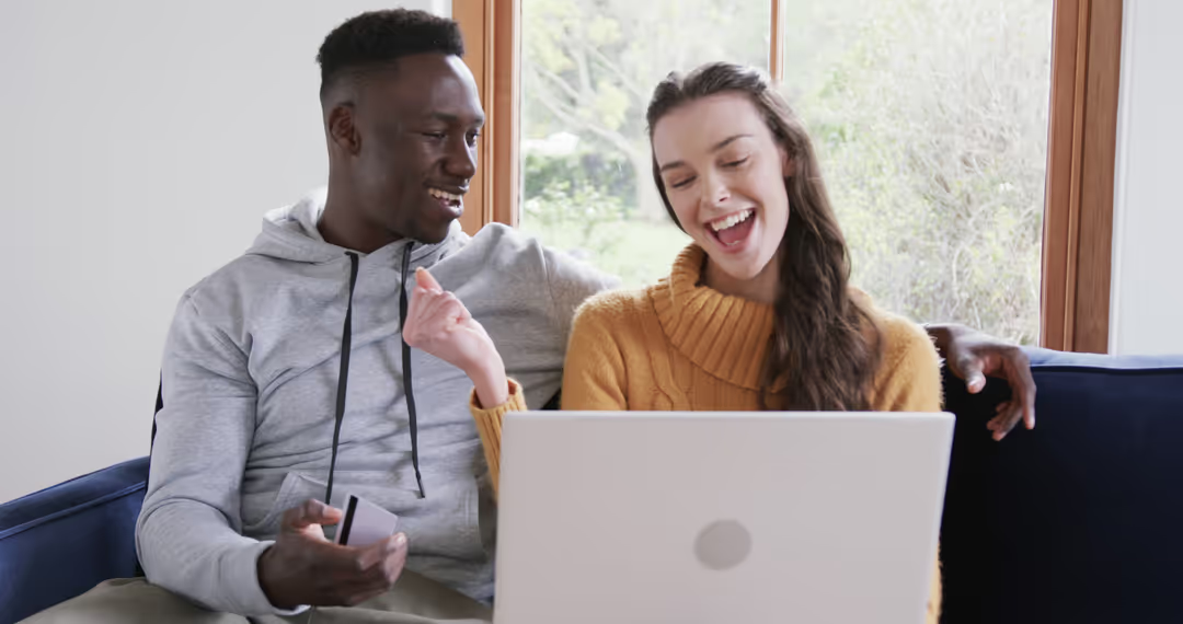 Happy Multiethnic Couple Online Shopping Together at Home